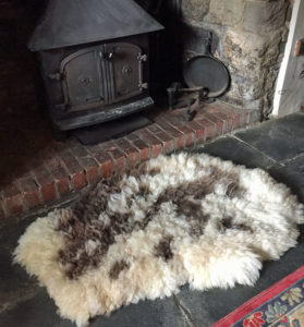 Felted Jacob sheepskin rug next to wood burner